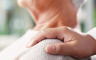 A hand on an elderly person’s shoulder.