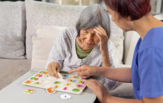 Nurse in nursing home helping a senior woman with number puzzle.