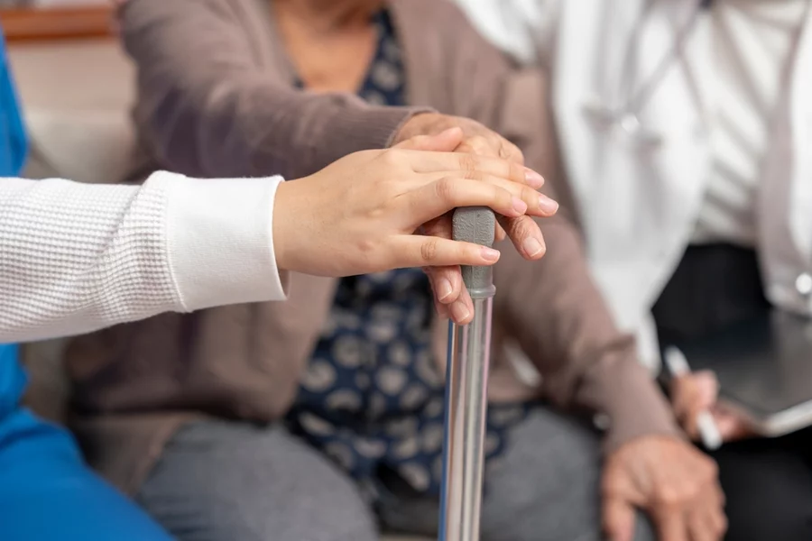 Close up of the hand of a nurse and aging woman.